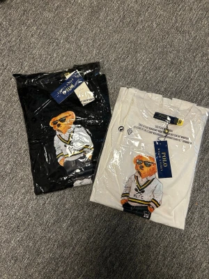 Polo Bear t-shirt från Ralph Lauren - Säljer 4 snygga t-shirt från Ralph Lauren med ikoniska Polo Bear-trycket framtill. Finns 2 svarta o två vita. Klassisk passform, korta ärmar och rund hals. Tillverkad i mjuk bomull som känns skön mot huden. Perfekt för dig som vill ha en stilren men lekfull look. 1 för 499, 2 för 900 ,3 för 1350 4 för 1700