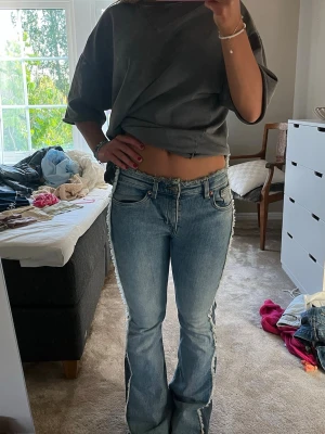 Blå bootcut jeans med fransade kanter - Säljer ett par ascoola jeans som är tvåfärgade! Har mest troligtvis klippt av lappen där storleken står men är antagligen storlek 34 