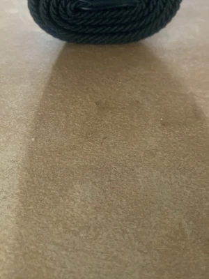 Svart flätat bälte i syntet - Snyggt svart bälte med flätad design och metallspänne. Bältet är gjort i syntetmaterial och passar perfekt till jeans eller byxor för en stilren look.
