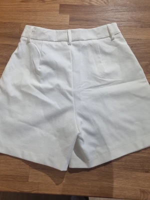 Vita shorts - I tjockare material och i ny skick, texturerat tyg.     #baggyjeans #lowwaist jeans #cargobyxor #vida jeans #flarejeans #lågmidja #rakajeans #kostymbyxor #mjukisbyxor #oversizedhoodie #ziphoodie #stickadtröja #corsettopp #offshoulder #babytee #linne med spets #oversized tshirt #stickadväst #maxikjol #y2k #vintage #streetwear #oldmoney #cleangirl #basic #festkläder #vardagskläder #unisex #oversized #fitted #cozy #retro #zara #hm #bikbok #ginatricot #nelly #nakd