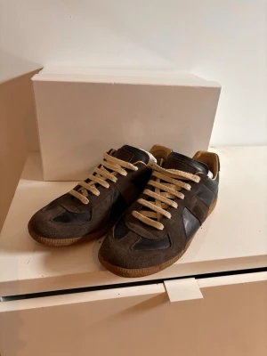 Maison Margiela gats - Säljer ett par fräscha gats från Maison Margiela med beigea skosnören och detaljer i både mocka och läder. Perfekta för en stilren och avslappnad look. Skorna är köpte förra året på Nordström och har knappt kommit till användning, därför gör jag mig av med den nu. Kvitto finns bland bilderna. Ställ gärna frågor!