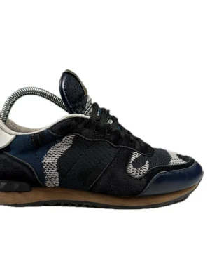Valentino Garavani camo sneakers - Snygga sneakers från Valentino Garavani med svart, blå och grå camomönstrad ovandel i mesh och mocka. Skorna har svarta snören, beige detaljer och en brun sula med svarta nitar på hälen. Perfekta för dig som vill sticka ut med stil.