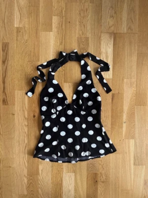 Svart prickig topp - Strl S | Y2K sommar - Trendig sommartopp som är enkel att styla! ✨  ☑️ Storlek S ☑️ Svart med vita prickar ☑️ Fint skick ☑️ Lätt och luftig modell ☑️ Perfekt till sommar och semester  Snygg och trendig topp med klassiskt prickigt mönster. Enkel att matcha med jeans, kjol eller shorts och passar till både vardag och utekväll.  Öppen för bud – skicka gärna ett meddelande vid intresse! 😊