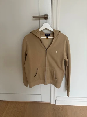 Polo Ralph Lauren hoodie - Snygg beige hoodie från Polo Ralph Lauren. Inga defekter storlek 14-16 som XS men kan passa till S