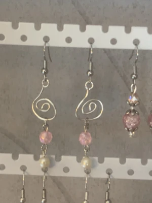 Silvriga örhängen med rosa pärlor och pärlemor - Unika handgjorda örhängen i silverfärgad metall med virvel design i rostfritt stål.                                             Rosa pärlor och pärlemor pärlor 