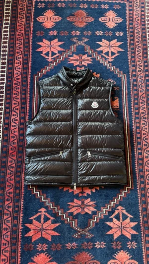 Moncler gui väst - Säljer nu min personliga Moncler Gui väst i storlek 1 vilket motsvarar S | västen är i nyskick utan något slitage | nyligen kemtvättad för att få tillbaks fluffet | perfekt till höst eller sommarkvällar | precis som allt annat vi säljer är den självklart äkta | vid frågor och funderingar tveka inte på att höra av er!                                                                                                                       Mvh Doré.reselll