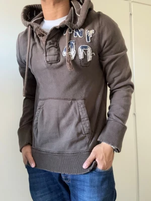 Vintage Abercrombie & Fitch Hoodie - As Snygg vintage  grå hoodie från Abercrombie & Fitch med broderad logga och text på bröstet. | Storlek S | Längd 67cm , Bredd Armhåla - Amrhåla 50cm | Mycket fint skick | Pris kan diskuteras! Modell 175 cm, 68kg