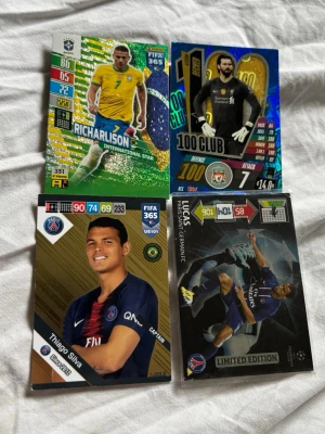 Fyra FIFA 365 samlarkort fotboll från Brasilien  - Säljer fyra FIFA 365 samlarkort med fotbollsspelare: Richarlison, Alisson Becker, Thiago Silva och Lucas Moura. Korten har färgstarka designer med spelarnas namn, lag och stats. Perfekt för dig som gillar att samla på fotbollskort eller vill byta med vänner.