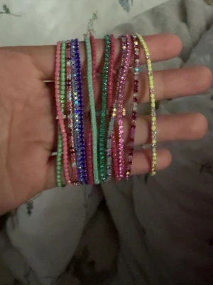 Färgglada glittriga pärlarmband - Säljer flera tunna armband med små pärlor i olika färger som rosa, blå, grön, gul och lila. 50kr per st! valfri färg! helt nya! 