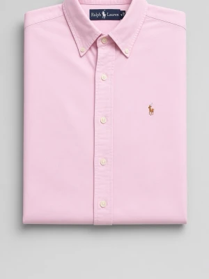 Ralph Lauren Classic Fit Oxfordskjorta – Rosa - Klassisk och tidlös Ralph Lauren oxfordskjorta i en fin, ljusrosa nyans. Skjortan har den ikoniska polo-spelaren broderad på bröstet och den välkända Ralph Lauren-loggan i nacken. •  Button-down krage •  Klassisk passform •  Mjuka, vita knappar •  100% bomullsoxford •  Ikonisk polo-spelare i brun/beige Skjortan är i mycket fint skick och ser ut som ny. Perfekt till både vardag och mer uppklätt – en riktig garderobsfavorit som aldrig går ur tiden.