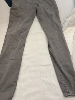 Gråa jack jones jeans - Säljer ett par gråa jeans med smal passform och klassisk femficksdesign. Jeansen har normal midja och raka ben. Materialet är bomull med lite stretch för extra komfort. Perfekta för dig som gillar en enkel och stilren look.