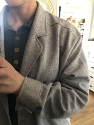 Oversized ljusgrå kavaj - Säljer en oversized ljusgrå kavaj med klassisk krage och knäppning framtill. Kavajen har en avslappnad passform och är tillverkad i ett mjukt tyg som ger en stilren look. Perfekt för dig som gillar en enkel men trendig stil.