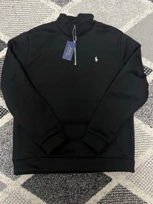 Polo Ralph quarter zip - En svart polo Ralph lauren quarter zip i nyskick, endast testad! Säljs på grund av att den var för stor.