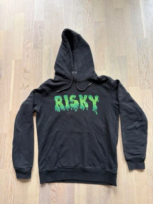 Svart hoodie med grön text RISKY - svart hoodie från Risky men grön text. Använd men mycket bra skick