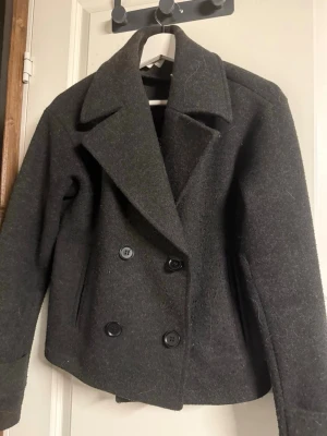Mörkgrå kappa  - Mörkgrå kappa från Kappahl i storlek xs, några noppor vid armarna men inget som är störande eller syns på långt håll