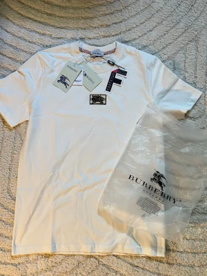 Burberry T-shirt  - Säljer en snygg, och oanvänd t shirt från Burberry! Tröjan kom aldrig till någon användning därmed säljer jag den! Priset går att diskuteras