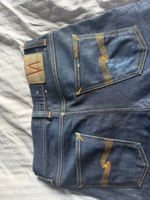 Nudie jeans lean dean - Ett par sköna mörkblå nudie jeans med en påbörjad slitning| str 28/30    | modell lean dean