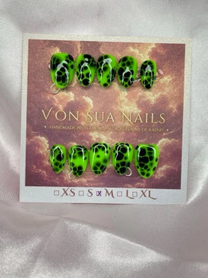Toxic (M);ExtraShortAlmond  - Unika handgjorda press-on naglar i en cool neongrön färg med svart, reptilinspirerat mönster. Naglarna har en blank finish och en extra kort mandel form som ger en edgy look. Perfekt för dig som vill sticka ut med dina naglar.M: 16 mm, 12 mm, 12,5 mm, 11,5 mm, 10 mm