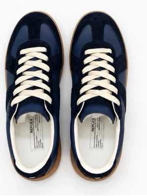 Marinblå sneakers med mockadetaljer - Snygga sneakers i marinblått med kontrasterande vita snören och gummisula. Ovandelen är en mix av slätt läder och mocka, vilket ger en stilren och sportig look. Perfekta för dig som gillar klassisk men trendig stil.