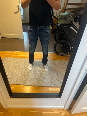 Replay blue jeans med slintnibgqr - Säljer ett par blå slim fit jeans med snygga kontrastsömmar och klassisk femficksdesign. Jeansen har normal midja och lätt tvättade detaljer för en avslappnad look. Perfekta till en enkel t-shirt eller hoodie.
