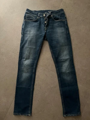 Dondup  - Tjena! Säljer dessa dondup jeans i storlek 31. Jeansen är i färgen blå. Jeansen har en omfattad defekt som sitter bredvid gylfen. Det är ett hål som kräver lagning. Se bilder. Vid frågor kontakta mig😀🙌🙌🙌