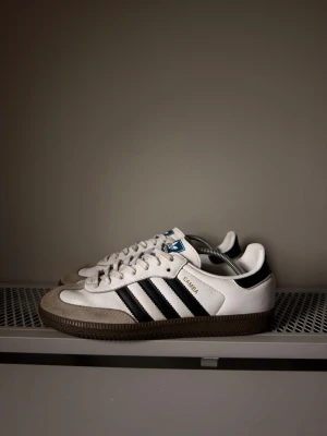 Adidas samba  - Säljer ett par adidas skor i modellen samba, den mest populära både modellen och färgen. Skorna är i ett väldigt bra skick med endast någon enstaka slitning (syns på bilderna) samt lite smutsiga skosnören. Annars är dem i ett extremt bra skick, ett par nya skosnören och de ser nästan helt nya ut. Storlek 42, nypris runt 1499:- mitt pris endast 699:-, hör av dig vid intresse!