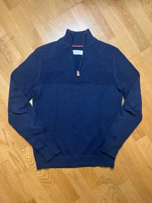 Mörkblå quarter zip tröja Pier One - Säljer denna mörkblåa stickade tröja från Pier One i storlek S (men passar mycket bra i M) med halv dragkedja och hög krage. Tröjan har ett snyggt strukturmönster upptill, ribbade muddar och är tillverkad i mjukt material. Perfekt för lager på lager och stilren look. Vid frågor, extra bilder eller liknande är det bara att kontakta mig!