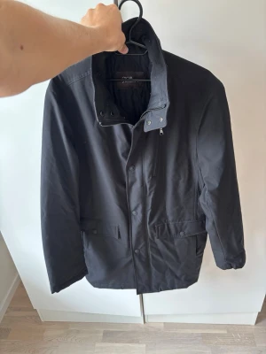 Svart ursnygg Oscar Jacobson trenchcoat 48 - Superfin svart elegant och eftertraktad Oscar Jacobson jacka i storlek 48 säljes! Galet snygg på och grym passform i superfint topp skick! Inga hål fläckar eller defekter och tveka inte vid minsta fråga eller fundering!
