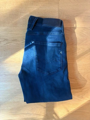 Mörkblå slim jeans - W29 L32 ,snygga mörkblå slim jeans med klassisk femficksdesign och normalhög midja. Jeansen har en smal passform och är tillverkade i ett stretchigt denimtyg som sitter bekvämt. Perfekta till vardagslooken och lätta att matcha med olika stilar.