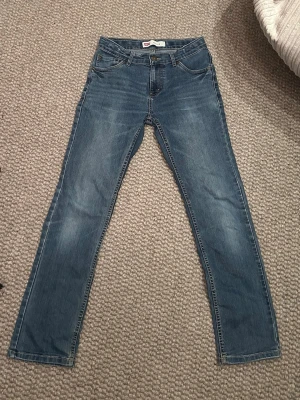 Levi’s 511 Slim Fit – Mörkblå, 14A - Snygga mörkblå Levi’s 511 i toppskick. Slim fit med en stilren färg som är enkel att matcha med både sneakers och skjorta, t-shirt eller hoodie.  Nypris ca 849 kr. Säljes för 649kr, men är öppen för bud vid en smidig affär.