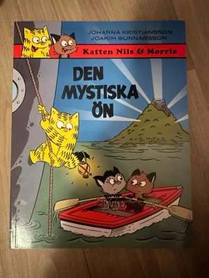 Katten Nils & Morris: Den mystiska ön - Seriealbum om Katten Nils, Morris och Semlan som ger sig ut på ett spännande äventyr till havs med vulkaner, mystiska ljussken och oväntade händelser. Perfekt för dig som gillar humor och äventyr. Boken är i ett fink skick och har 124 sidor. 