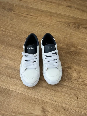 Vita Polo Ralph Lauren sneakers - snygga vita skor från polo ralph lauren som är använd få gånger. Passar bra i vardagen men även om du vill klä upp dig lite. köpa för över 800kr