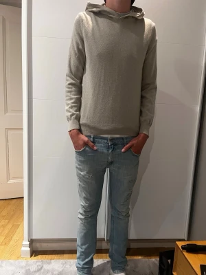 Beige hoodie i mjukt material - Säljer en stilren beige hoodie från Oscar Jacobson. Materialet är väldigt skönt o h bekvämt att ha på sig, ite jätte nopprig. Bara att höra av er om ni har frågor 