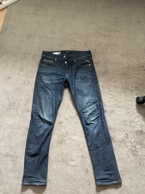 Replay Grover  - Säljer ett par mörkblå jeans i modellen straight fit från Grover. Klassisk femficksdesign med snygga kontrastsömmar och knappgylf. Perfekta till vardagslooken och passar till det mesta. Jeansen har en stilren tvätt och raka ben.