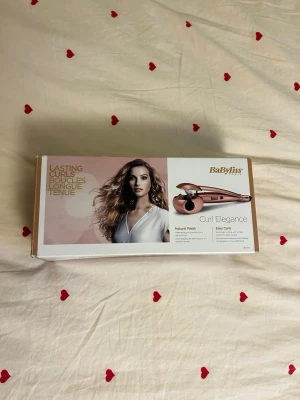 Locktång - Säljer en BaByliss Curl Elegance locktång i roséguld. Perfekt för att skapa naturliga lockar med enkelhet. Kommer i originalförpackning med snygg design och tydliga instruktioner på lådan.