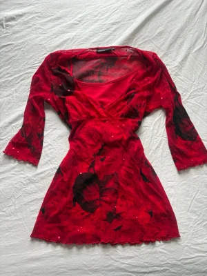 Röd glittrig babydoll top/ mini dress  - Går att använda som topp eller mini dress beroende på vad man föredrar 💓💓 glittriga detaljer på hela plagget i guld 