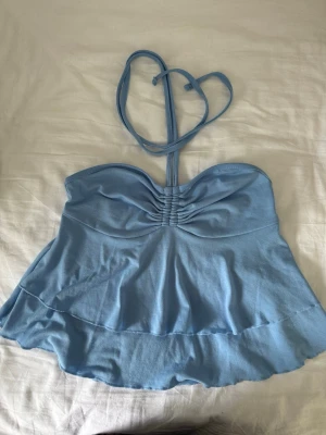 Ljusblå bandeau topp  - Supersöt ljusblå bandeau topp från SHEIN med halterneckband och rynkade detaljer framtill. Toppen har en volangkant nedtill. 