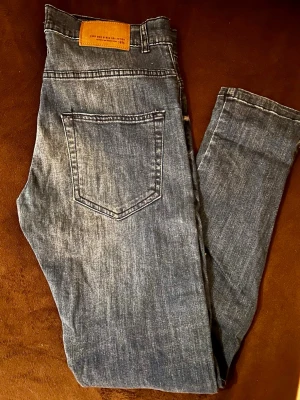 Zara Man Z1975 Bikerjeans m. Dragkedjor - Superfeta bikerjeans från Zara Man 1975 i blågrå tvätt. Cool design med dekorativa dragkedjor, mc-paneler och snygga slitningar. Sitter riktigt bra då de har skön stretch! Toppskick utan dolda defekter. Se bilderna för exakta mått. •Märke: Zara Man •Storlek: EUR 38 / US 30 •Material: 99% bomull, 1% elastan •Mått (platt):Midja: 44cm Innerben: 74cm Längd: 101cm Fotvidd: 15cm Fraktar snabbt via Plick! Skriv vid frågor eller för fler bilder ✨