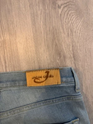 jeans Jacob Cohen - Säljer ett par ljusblå jeans från Jacob Cohen med raka ben och klassisk femficksmodell. Jeansen har en snygg tvätt med slitningar på låren och är tillverkade i mjukt denimtyg. Perfekta för en avslappnad och trendig look.