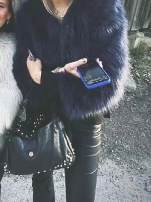 Mörkblå fluffig pälsjacka - Säljer en svart, superfluffig pälsjacka med bred krage och lång ärm. Jackan har en oversized passform och ger en riktigt lyxig vibe. Perfekt för att hålla sig varm och snygg under kalla dagar. Matcha med svarta jeans för en clean look.