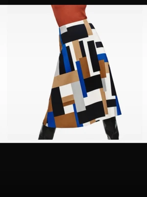Färgstark långkjol med grafiskt mönster, Lindex S - Snygg långkjol med grafiskt blockmönster i svart, blått, vitt, beige och brunt. Kjolen har en rak och stilren form som ger en modern look. Perfekt för dig som vill sticka ut med färg och mönster. Tillverkad i ett mjukt och följsamt polyestertyg.