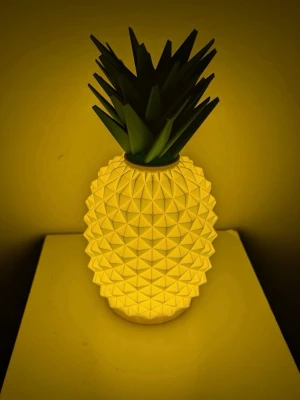 Ananasformad lykta - Cool lampa formad som en ananas med gul kropp och gröna blad. Lykta  har en geometrisk yta och ger ett mysigt sken, perfekt som dekoration i rummet. Tillverkad i plast och passar dig som gillar färgglada detaljer.  LED värme ljus hänger med