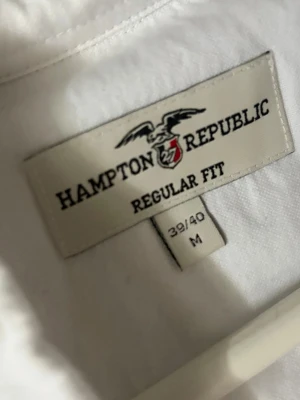 Vit skjorta från Hampton Republic - Klassisk vit skjorta från Hampton Republic i regular fit. Skjortan har lång ärm, bröstficka och knäppning framtill. Perfekt för en clean och stilren look. Storlek M (39/40).