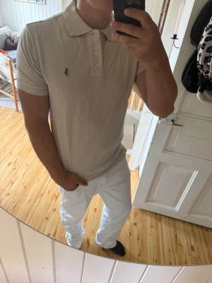 Ralph lauren piké - Säljer nu en riktigt snygg Ralph lauren Piké i beige/sand färg, tröjan är i storlek L och den har inga tecken på användning utan är i princip i nyskick! 