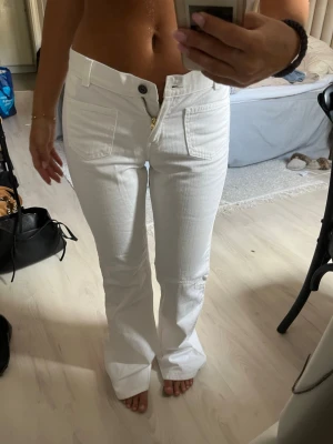 Vita bootcut jeans med mid waist - Säljer ett par vita jeans med bootcut-modell. Jeansen har framfickor, bälteshällor och stängs med dragkedja och knapp. Materialet är denim. Perfekta till sneakers eller klackar. Oanvända😍
