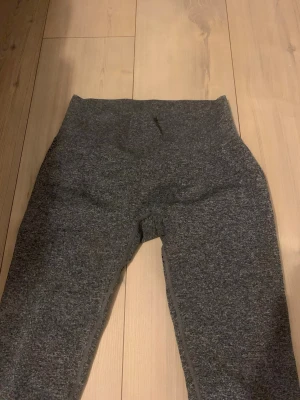 Mörkgrå sömlösa leggings - Snygga mörkgrå leggings i stretchigt, sömlöst material. Hög midja och diskret mönsterdetalj baktill och längs sidorna för extra stil. Perfekta för träning eller chill. Materialet känns mjukt och följsamt.
