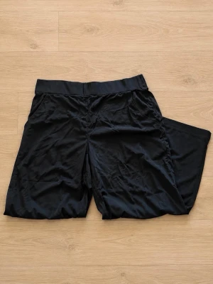 Svarta vida byxor från Street One XL/42 - Svarta tunna byxor från Street One med loose passform och bred resår i midjan. Bred stretchig resår. Perfekta för varma dagar när du vill ha det bekvämt och stilrent.