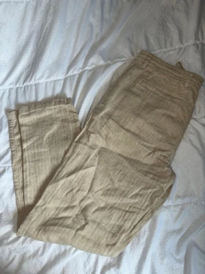 Beiga linnebyxor från Denim Day - Snygga beiga linnebyxor från Denim Day i storlek L. Byxorna har dragsko i midjan, fickor och är tillverkade i ett luftigt linnematerial. Perfekta för en avslappnad och trendig stil.