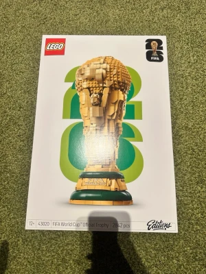 LEGO FIFA World Cup Trophy 2842 bitar - Byggsats från LEGO som föreställer FIFA World Cup Trophy. Setet innehåller 2842 bitar i guld- och gröna nyanser och har officiell FIFA-licens. Perfekt för fotbollsälskare och samlare som gillar utmanande byggprojekt. Paketet e helt oöppnat och jag har aldrig rört den.