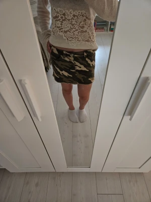 Jeans kjol - Säljer en camouflage-mönstrad kortkjol i klassisk jeansmodell. Kjolen har fickor fram och bak. Helt oanvänd och inga defekter